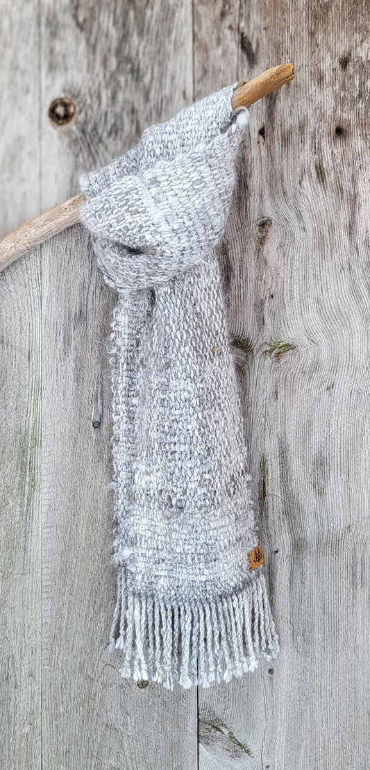 Håndvevd angoraskjerf tekstur drapert over trepinne med rustikk gammel dør som bakgrunn