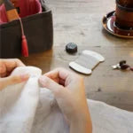 Hender som broderer med sytilbehør