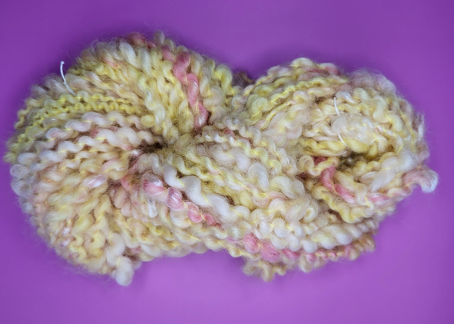 Håndspunnet kunstgarn i gultoner med litt rosa