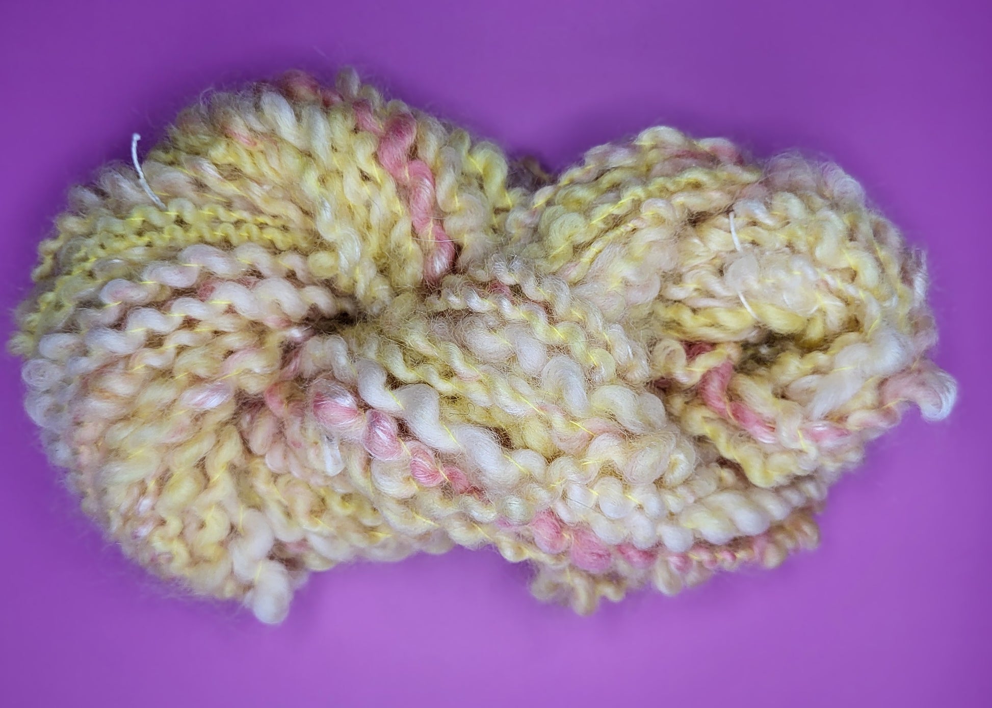 Håndspunnet kunstgarn i gultoner med litt rosa